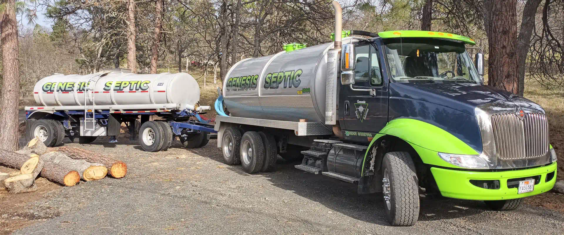 black green truck with septic tanks on a road